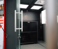 Blick in einen Technikcontainer der Stadtwerke Osnabrück mit installierter Luft-Wasser-Wärmepumpe und Steuerungseinheit im Rahmen des Wärmepumpen-Komplettpakets.