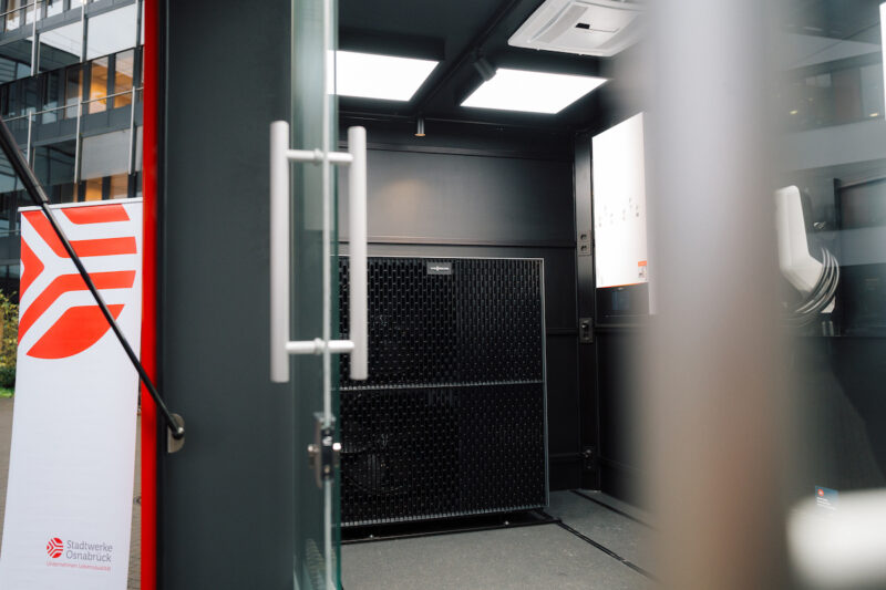 Blick in einen Technikcontainer der Stadtwerke Osnabrück mit installierter Luft-Wasser-Wärmepumpe und Steuerungseinheit im Rahmen des Wärmepumpen-Komplettpakets.