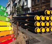 Kommunale Wärmeplanung: Ein Stapel neuer Rohre für Fernwärme an einer Baustelle, Grafik mit Energieeffizienzklassen für Gebäude nach dem GEG, Düsseldorf, Deutschland.