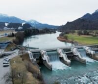Ein Laufwasserkraftwerk vor Schweizer Alpenkulisse.
