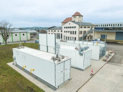 mehrere weiße Container auf einer Fläche vor Gebäuden - Test der Wasserstoff-Beimischung