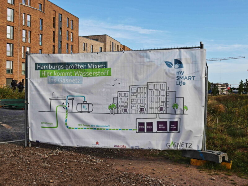 Informationstafel zu Wasserstoff auf einer Baustelle in einem Wohngebiet
