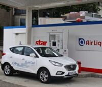 Ein Wasserstoffauto steht vor einer Tankstelle.