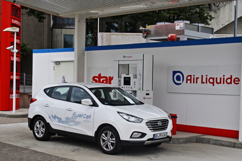 Ein Wasserstoffauto steht vor einer Tankstelle.
