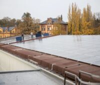 Montage von Solarmodulen auf einem hitorischen Wasserwerk im Herbstlaub.