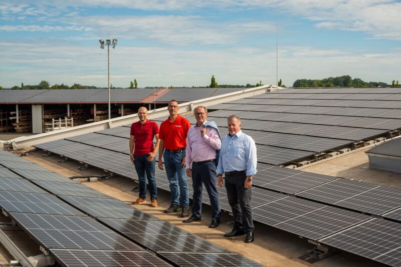 4 Personen inmitten einer gewerblichen PV-Großanlage.