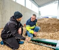 Zwei Männer in einem Hackschnitzellager.