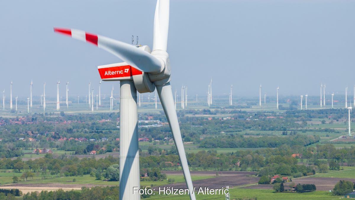 Close-Up einer Windturbine vor dem HIntergrund vieler Anlagen im Flachland.
