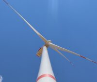 Blick entlang einer Windenergie-Anlage von unten nach oben - Wald ist nicht zu sehen.