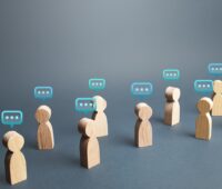 Holzfiguren mit Sprechblasen - Symbol für Kommunikation