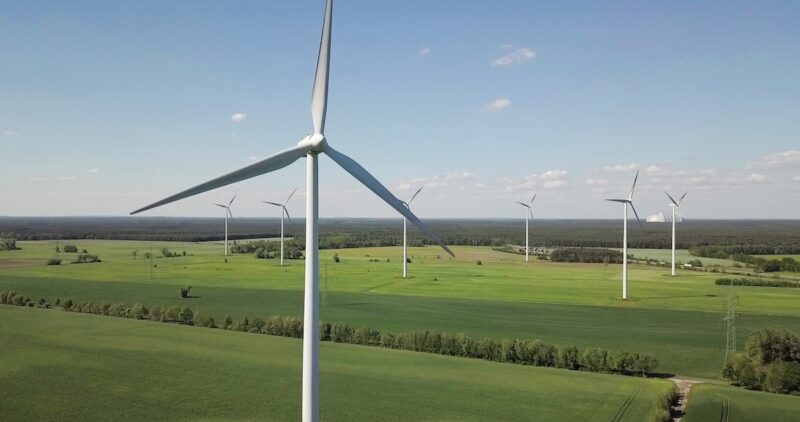 Windenergie-Anlagen auf flachem Land aus der Luft aufgenommen - Windpark von Qualitas vor dem Repowering