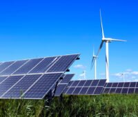 Freiflächen-Photovoltaikanlage vor Windenergieanlagen - Symbolbild für Beschleunigungsgebiete für beide Technologien