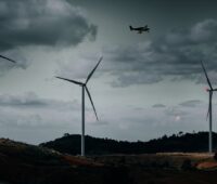 Zu sehen ist ein Windpark in der Dämmerung. Hier soll die bedarfsgesteuerte Nachkennzeichnung zum Einsatz kommen.