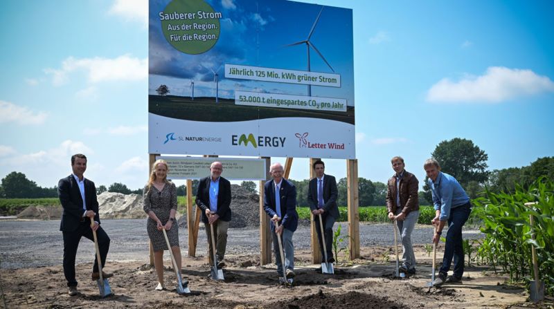 Sieben Personen bei einem Spatenstich für einen Windpark.