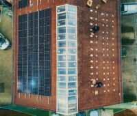 Vogelperspektive auf ein Spitzdach mit Solaranlage auf linker Seite.