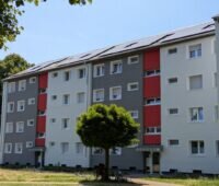 Mehrfamilienblock aus den 1950er Jahren mit neuen PV-Anlagen auf dem Dach.