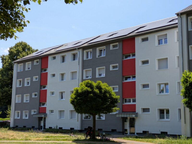 Mehrfamilienblock aus den 1950er Jahren mit neuen PV-Anlagen auf dem Dach.