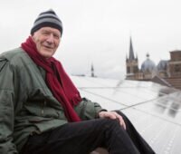 Wolf von Fabeck sitzend auf einen Solardach in Aachen.