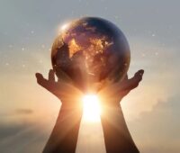 Zwei Hände halten einen Globus in die Sonnen als Symbol für den Erdüberlastungstag.