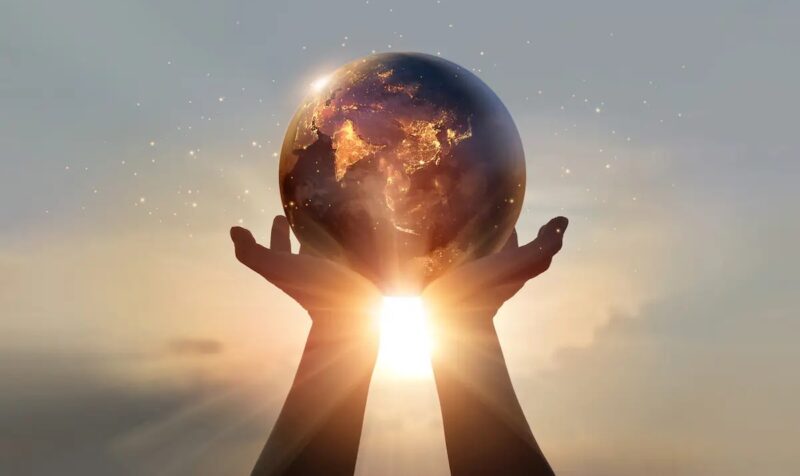 Zwei Hände halten einen Globus in die Sonnen als Symbol für den Erdüberlastungstag.