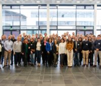 Gruppenbild von rund einhundert Personen in einem Foyer.