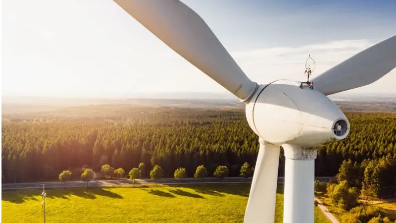 Zu sehen ist eine Windkraftanlage in idyllischer Umgebung. Je näher Windkraftanlagen in der Umgebung stehen, desto geringer ist das Interesse der Bürger:innen am Ökostrom.