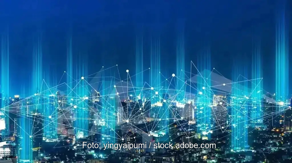 Eine Stadt bei Nacht mit einem Netz aus blau leuchtenden Knotenpunkten - Symbol für Peer to Peer Stromhandel.