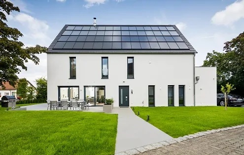 Zu sehen ist ein vorbildliches Gebäude mit einem Solarenergie-Dach, das Anforderungen einer möglichen Novelle des Gebäudeenergiegesetzes bereits heute spielend erfüllt.
