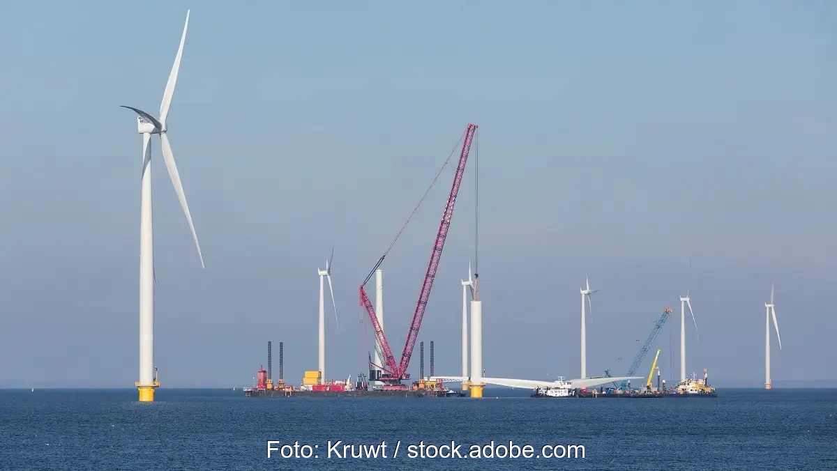Ein Kran und Windenergieanlagen im Meer, die Offshore-Wind-Branche fordert bessere Rahmenbedingungen.
