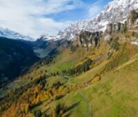 Steiler Berghang mit Gras und felsigen Gipfeln im Sonnenlicht - ein Platz für alpine PV
