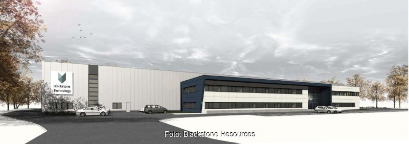 Ein modernes Fabrikgebäude vor herbstlichem Himmel.