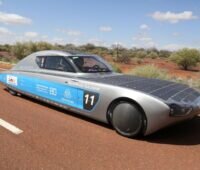 Ein Rennwagen mit Solarzellen auf einer Straße in der Wüste Australiens.