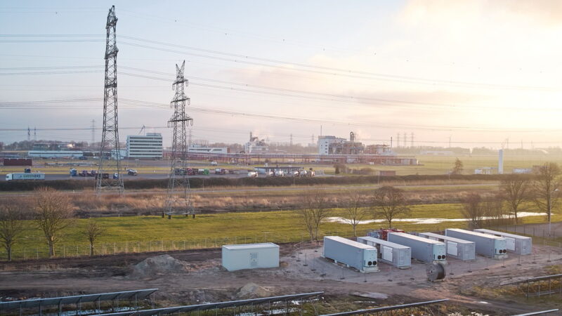 Batteriespeicher und PV-Anlage entlang einer Autobahn und Stromleitungen.