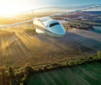 Ein Flugzeug mit DLR-Symbol fliegt über eine Landschaft zum Sonnenuntergang.