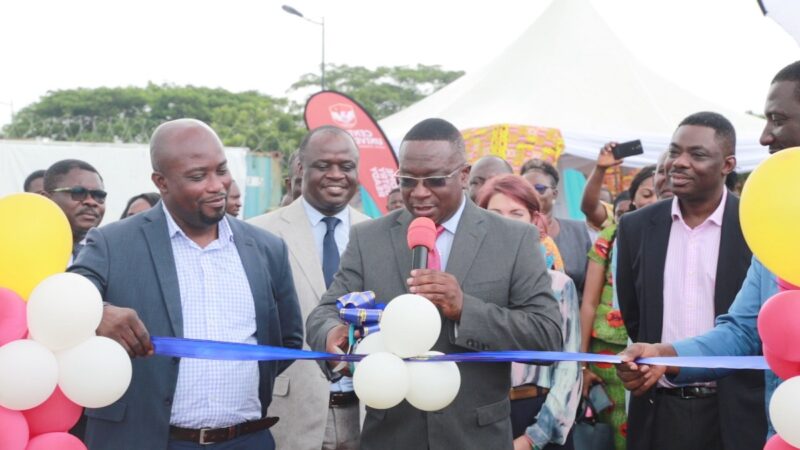 Ein Offizieller schneidet das band bei der Eröffnung der Solaranlage für die Universität in Ghana durch.