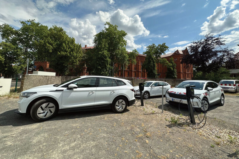 Elektro-PKW mit Ladesäulen in einem städtischen Fuhrpark.