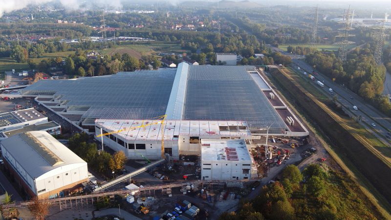 Luftbild einer großen Solarthermieanlage neben Schnellstrasse auf einem Industriegelände.