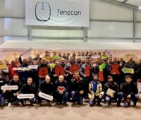 Gruppenfoto in Firmenhalle mit Logos von Enerix und Fenecon