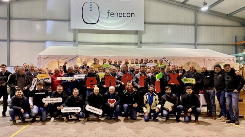 Gruppenfoto in Firmenhalle mit Logos von Enerix und Fenecon