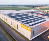 Luftbild einer Logistikhalle mit Solarmodulen auf dem Dach.