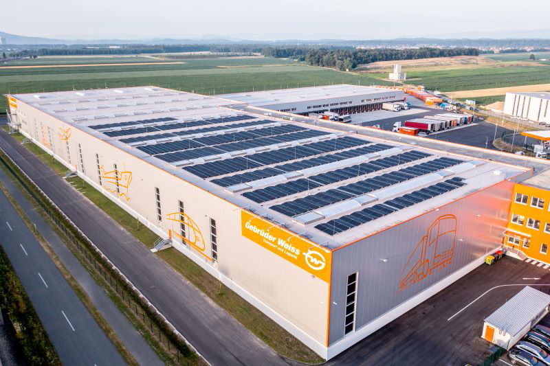 Luftbild einer Logistikhalle mit Solarmodulen auf dem Dach.