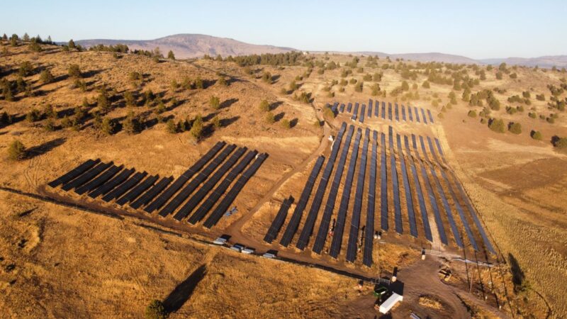 Luftaufnahme einer PV-Freiflächenanlage in einer trockenen Landschaft.