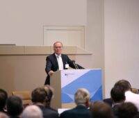 Jochen Homann, Präsident der Bundesnetzagentur bei einer Rede vor einer Konferenz am Pult.
