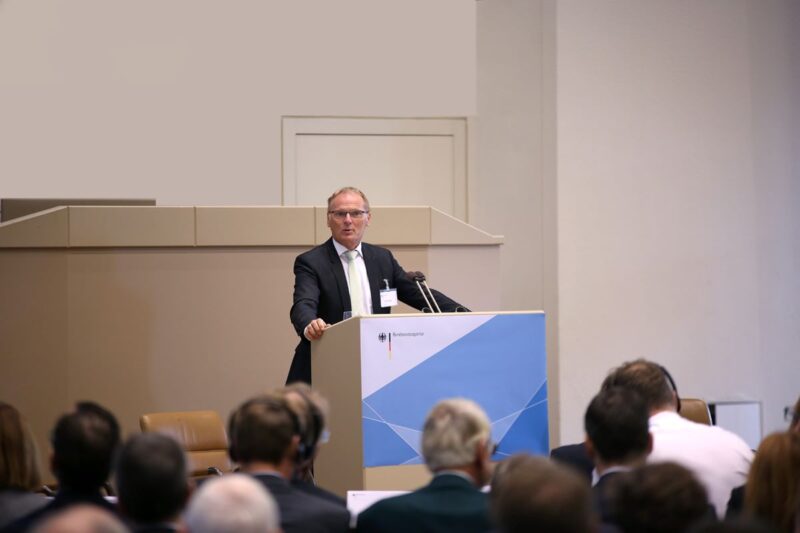 Jochen Homann, Präsident der Bundesnetzagentur bei einer Rede vor einer Konferenz am Pult.