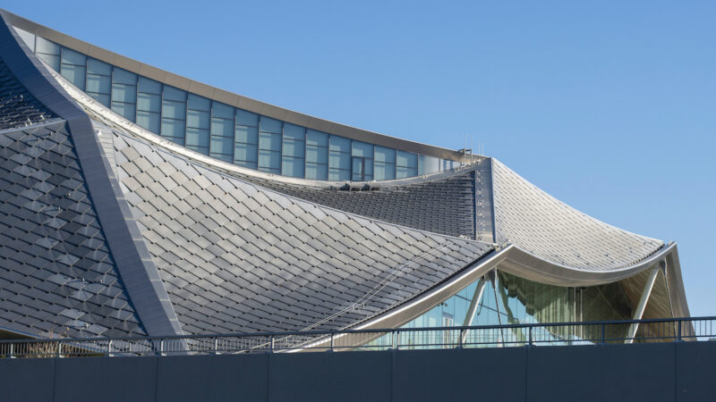 Das geschwungene Dragonscale-Dach der Google-Gebäude Bay View in Mountain View mit zahlreichen rautenförmig angeordneten silbernen Solarmodulen.