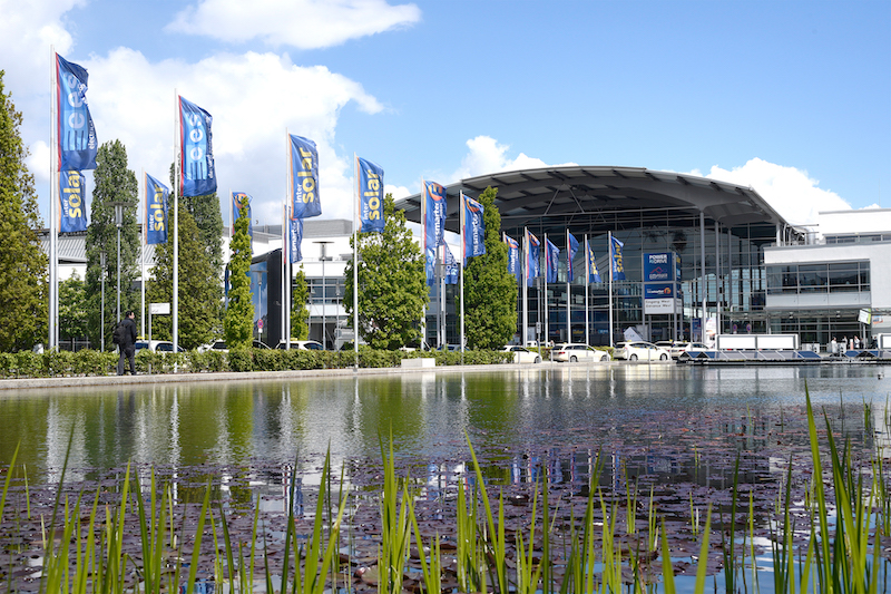 Messe-Gelände in München: Blick über den Teich auf Intersolar-Fahnen und die Messehallen.