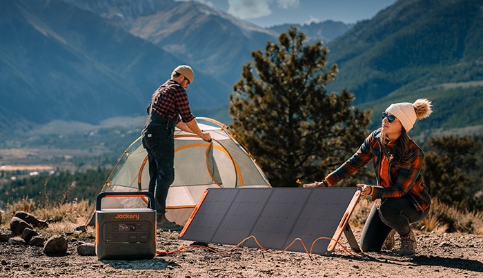 Das Bild zeigt zwei Camper in der Natur, die den Solargenerator 1500 Pro vor ihrem Zelt aufgebaut haben.