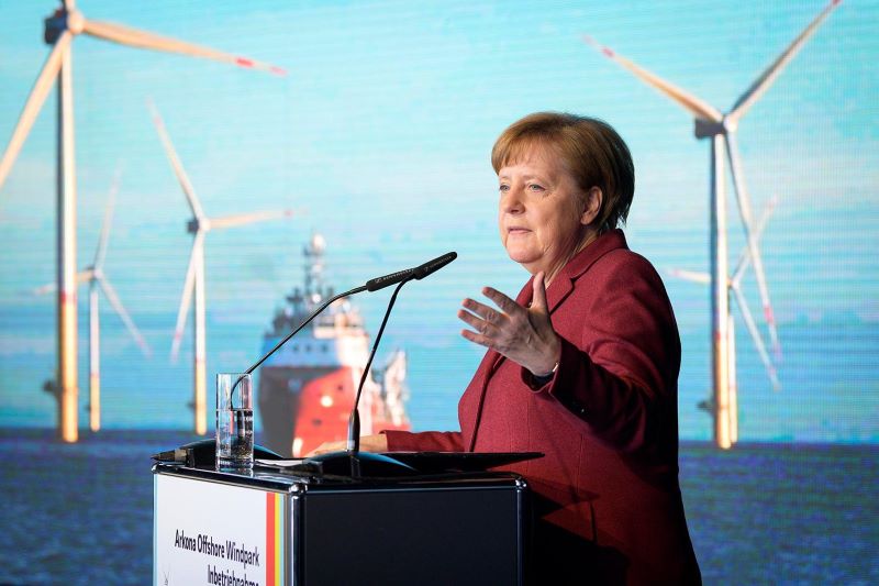 Bundeskanzlerin Angela Merkel mit Offshore-Windpark im Hintergrund