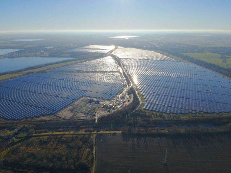 Luftbild eines 600 MW großen Solarparks bei tief stehender Sonne.