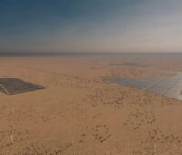 Flache Sandwüste aus der Luft mit Photovoltaikanlagen und Windenergie